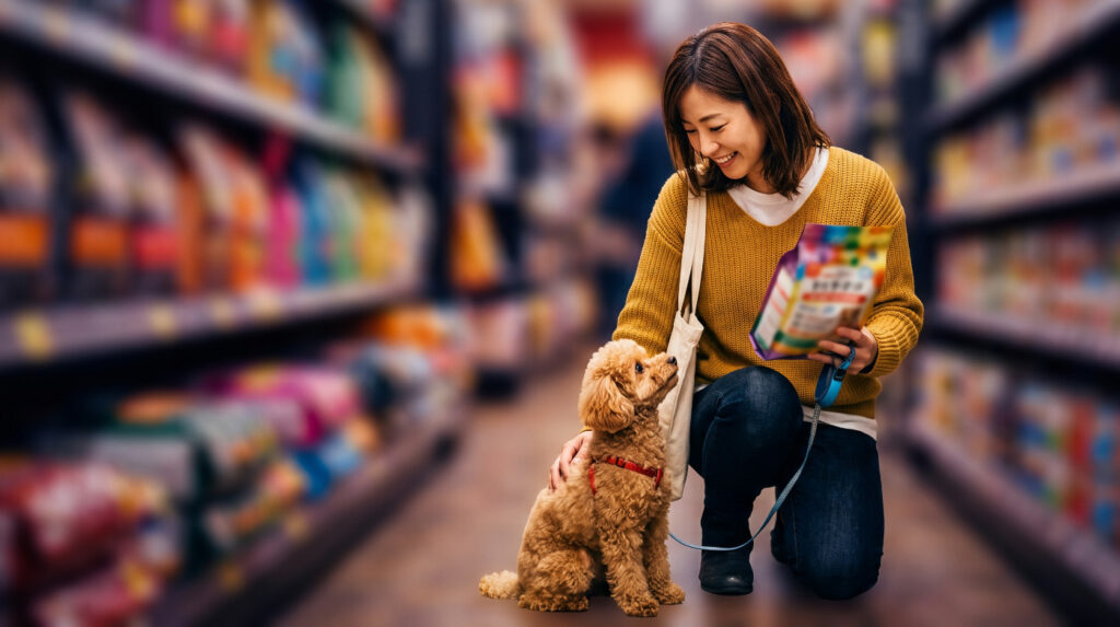 ドッグフードの売り場でどれにしようか考える飼い主と愛犬