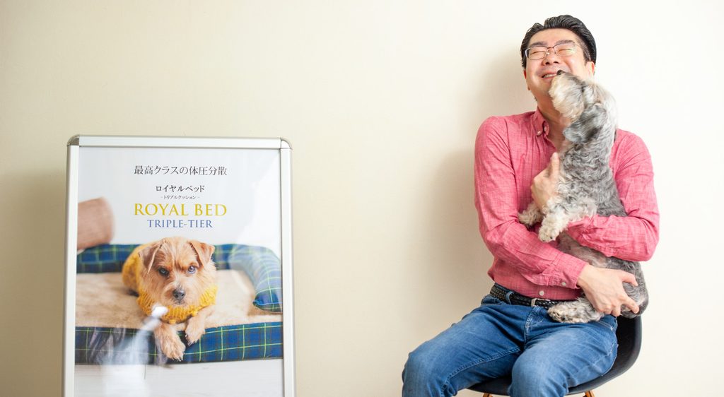 オープンセオリー株式会社代表取締役社長の山本健一と愛犬ムックくん、ロイヤルベッド本体のパネル